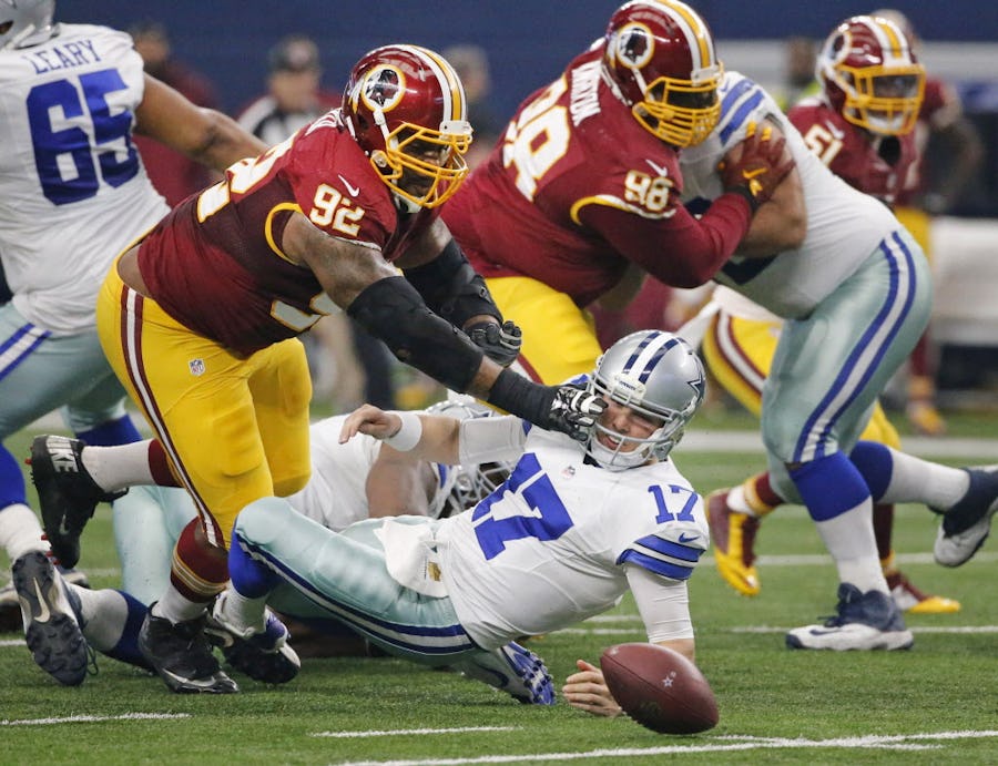 Washington Redskins defensive end Chris Baker (92) mows over Dallas Cowboys quarterback Kellen Moore (17) to recover a fumble after Moore fumbled the snap in the first quarter during the Washington Redskins vs. the Dallas Cowboys NFL football game at AT&T Stadium in Arlington on Sunday, January 3, 2016. (Louis DeLuca/The Dallas Morning News)