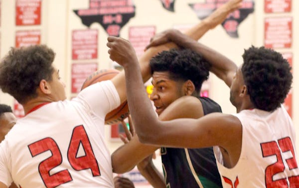 DeSoto post Marques Bolden (22) found himself trapped by the aggressive defense of Cedar Hill forward Terrence Jones (23) and Zach Simmons (24) during first half action. The two teams played their District 8-6A basketball game at Cedar Hill High School on January 15, 2016. (Steve Hamm/Special Contributor)