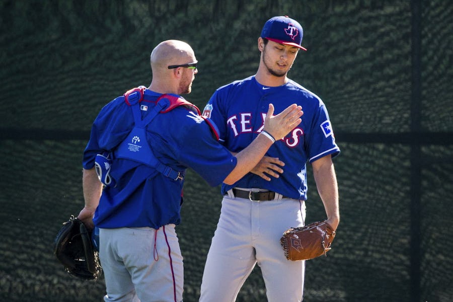 Texas Rangers pitcher Yu Darvish gets a congratulatory pat from catcher Chris Gimenez after throwing from a half pitching mound during a spring training workout at the team's training facility on Monday, Feb. 22, 2016, in Surprise, Ariz. Darvish is recovering from Tommy John surgery. (Smiley N. Pool/The Dallas Morning News)