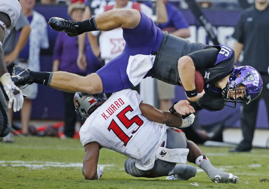 TCU quarterback Matt Joeckel (16) is upended by Texas Tech defensive back Keenon Ward (15) in the fourth quarter during the Texas Tech University Red Raiders vs. the TCU Horned Frogs college football game at Amon G. Carter Stadium in Fort Worth on Saturday, October 25, 2014.  (Louis DeLuca/The Dallas Morning News)
