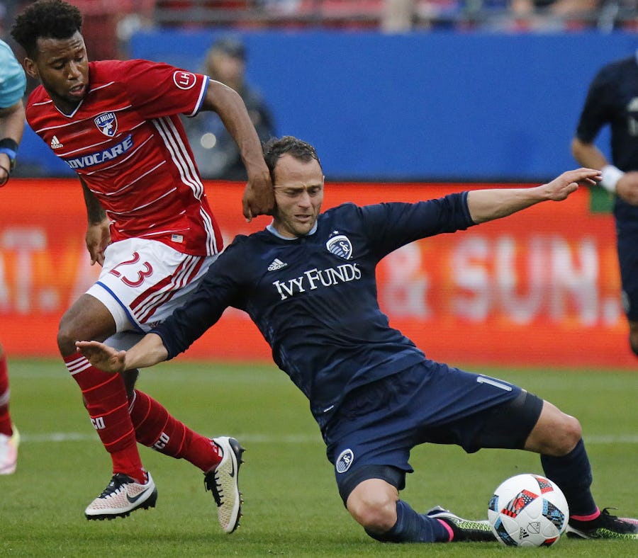 FC Dallas midfielder Kellyn Acosta (23) tries to make a play on the soccer ball as Sporting Kansas City midfielder Brad Davis (11) falls to the ground during the first half as FC Dallas hosted Sporting KC at Toyota Stadium in Frisco on Sunday, April 17, 2016. (Stewart F. House/Special Contributor)