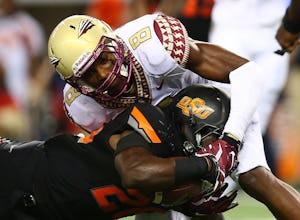 ARLINGTON, TX - AUGUST 30: Desmond Roland #26 of the Oklahoma State Cowboys is tackled by Jalen Ramsey #8 of the Florida State Seminoles in the fi rst half of the Advocare Cowboys Classic at AT&T Stadium on August 30, 2014 in Arlington, Texas. (Photo by Ronald Martinez/Getty Images)
