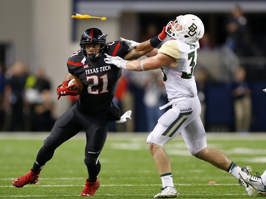 Texas Tech Red Raiders running back DeAndre Washington (21) gives Baylor Bears safety Collin Brence (38) a stiff arm on their final drive of the game at AT&T Stadium in Arlington, Texas, Saturday, November 29, 2014. A face masking penalty negated the run. (Tom Fox/The Dallas Morning News)