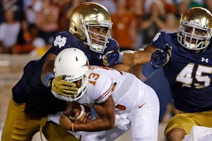 SOUTH BEND, IN - SEPTEMBER 05: Jerry Tillery #99 of the Notre Dame Fighting Irish tackles Jerrod Heard #13 of the Texas Longhorns for a loss of yards during the second quarter at Notre Dame Stadium on September 5, 2015 in South Bend, Indiana. (Photo by Jon Durr/Getty Images) 09122015xPUB