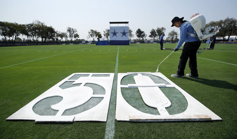 Robert Vega of Oxnard City Corps spray paints the 50 yard line markers on a practice field in preparation for tomorrow's start of Dallas Cowboys training camp in Oxnard, California, Friday, July 29, 2016. (Tom Fox/The Dallas Morning News)