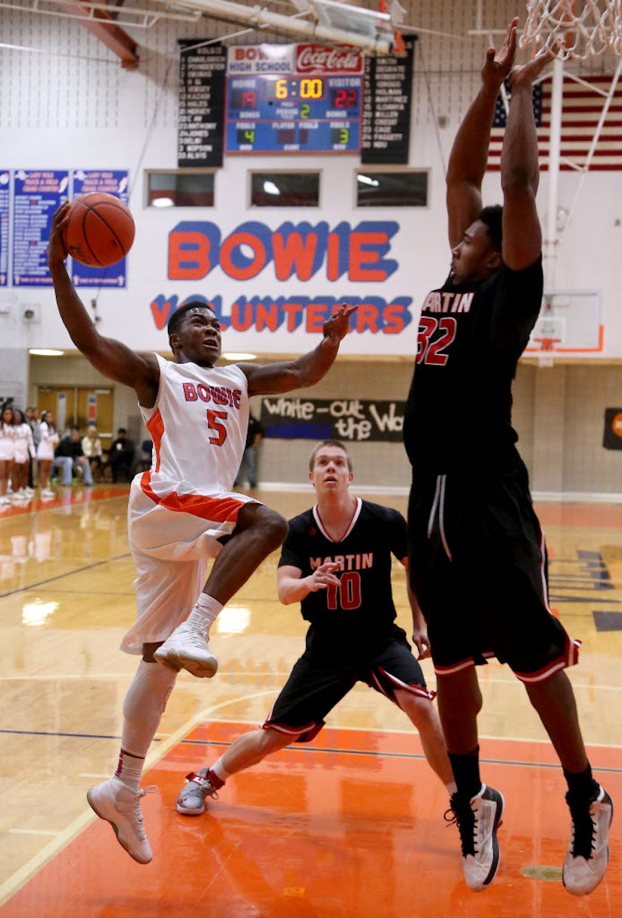 Arlington Bowie Volunteers guard Brandon Hall (5) drives against Arlington Martin Warriors forward Myles Garrett (32) in the first half of high school boy's basketball action at Bowie High School in Arlington, Texas on Tuesday, February 11, 2014.  (Brad Loper/The Dallas Morning News)