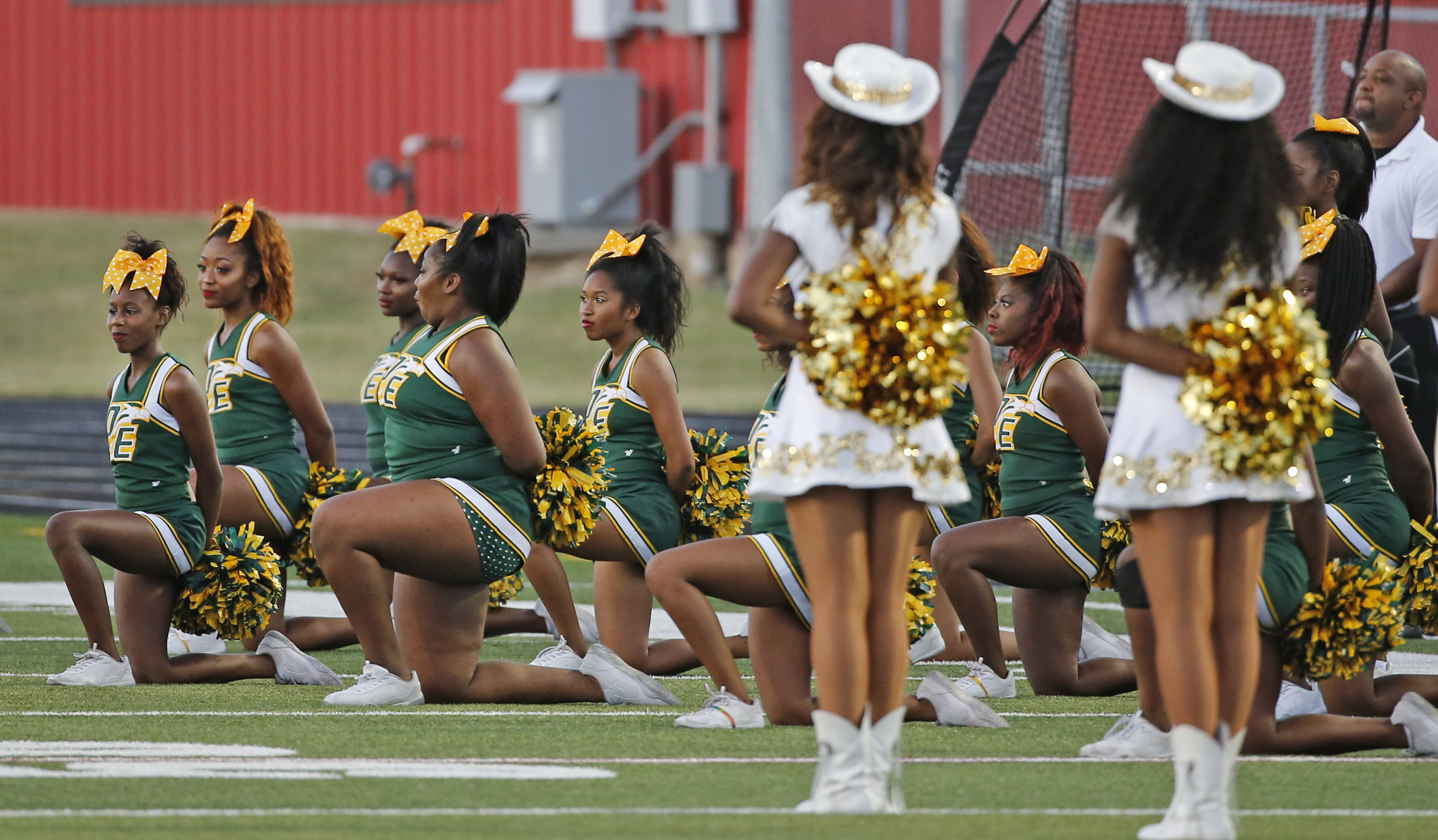 49ers cheerleader takes a knee during anthem before Raiders game