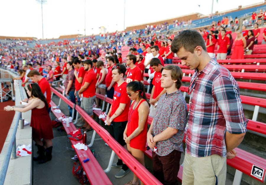 Southern Methodist Mustangs student Kenny Oostman (right) and his classmates bow their heads in prayer before their game against TCU at Gerald J. Ford Stadium in University Park, Texas, Friday, September 23, 2016. (Tom Fox/The Dallas Morning News)