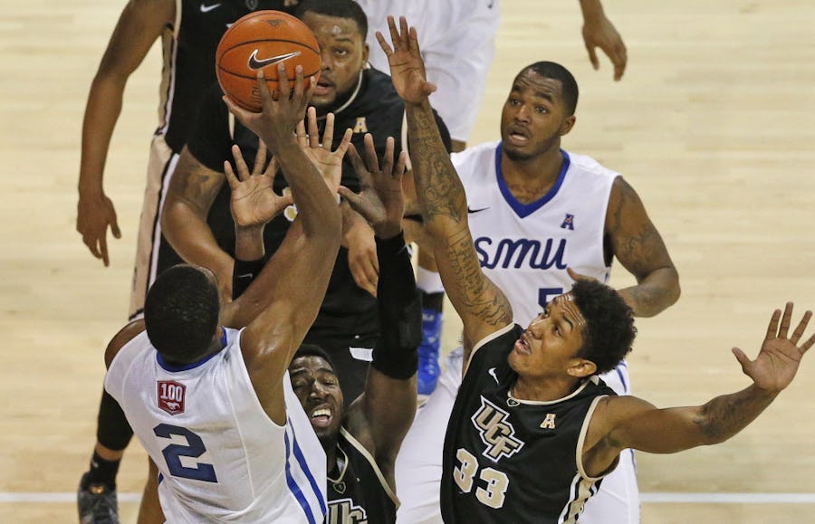SMU's Yanick Moreira (2) shoots in traffic as UCF's Shaheed Davis (33) defends in the first half during the Central Florida University Knights vs. the SMU Mustangs college basketball game at Moody Coliseum in Dallas on Saturday, January 31, 2015.  (Louis DeLuca/The Dallas Morning News)