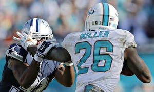 Miami Dolphins running back Lamar Miller (26) gets his hand in the helmet of Dallas Cowboys free safety Byron Jones during the second half Dallas' 24-14 win at Sun Life Stadium Sunday, November 22, 2015 in Miami Gardens, Fla. (G.J. McCarthy/The Dallas Morning News)
