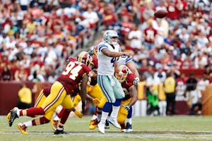 Dallas Cowboys quarterback Dak Prescott (4) evades Washington Redskins outside linebacker Preston Smith (94) and other defenders as he completes a pass to Dallas Cowboys tight end Geoff Swaim (87) during the second half of play at FedEx Field in Landover, Maryland on Sunday, September 18, 2016. The Dallas Cowboys defeated the Washington Redskins 27-23. (Vernon Bryant/The Dallas Morning News)