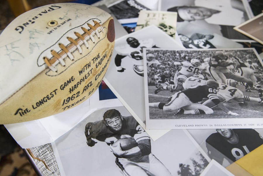 A game ball from the 1962 AFL Championship game and photos taken by sports photographer Brad Bradley are scattered on a table on Wednesday, November 2, 2016 at Bradley's home in Highland Park, Texas. (Ashley Landis/The Dallas Morning News)