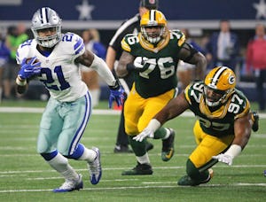 Dallas Cowboys running back Ezekiel Elliott (21) breaks through the line for good yardage in the second half during the Green Bay Packers vs. the Dallas Cowboys NFL football playoff game at AT&T Stadium in Arlington, Texas on Sunday, January 15, 2017. (Louis DeLuca/The Dallas Morning News)