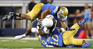 Texas Longhorns wide receiver Marcus Johnson (7) is tackled by UCLA Bruins defensive back Fabian Moreau (10) and linebacker Eric Kendricks (6) in the third quarter at AT&T Stadium in Arlington, Texas, Saturday, September 13, 2014. (Tom Fox/The Dallas Morning News) 04282015xSPORTS