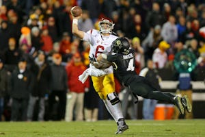 BOULDER, CO - NOVEMBER 13: Quarterback Cody Kessler #6 of the USC Trojans is hit by defensive back Chidobe Awuzie #4 of the Colorado Buffaloes while throwing a pass during the third quarter at Folsom Field on November 13, 2015 in Boulder, Colorado. The Trojans defeated the Buffaloes 27-24. (Photo by Justin Edmonds/Getty Images) ORG XMIT: 585852631