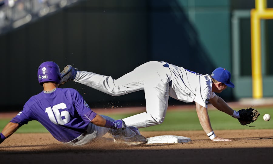 TCU's Connor Wanhanen (16) slides safely to second base as Florida second baseman Deacon Liput chases the ball on a throwing error in the third inning of an NCAA College World Series baseball game in Omaha, Neb., Sunday, June 18, 2017. (AP Photo/Nati Harnik)