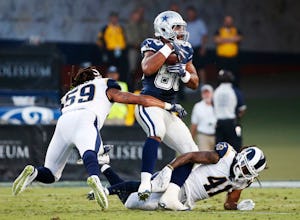 Dallas Cowboys tight end Rico Gathers (80) catches the ball amongst Los Angeles Rams outside linebacker Josh Forrest (59) and Los Angeles Rams defensive back Marqui Christian (41) on a third down attempt during the first half of play in a preseason game between the Dallas Cowboys and Los Angeles Rams at Los Angeles Memorial Coliseum in Los Angeles, California on Saturday, August 12, 2017. (Vernon Bryant/The Dallas Morning News)