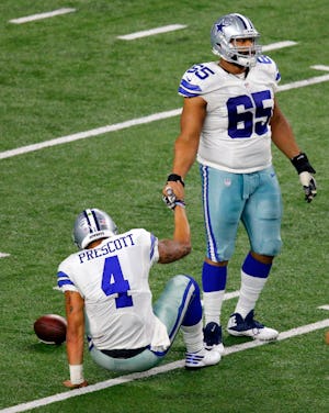 Dallas Cowboys quarterback Dak Prescott (4) receives a hand from guard Ronald Leary (65) after being sacked by Green Bay Packers outside linebacker Nick Perry during the fourth quarter of their NFC Divisional playoff game at AT&T Stadium in Arlington, Texas, Sunday, January 15, 2017. (Tom Fox/The Dallas Morning News)