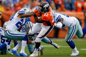 DENVER, CO - SEPTEMBER 17: Running back C.J. Anderson #22 of the Denver Broncos escapes from a group of Dallas Cowboys defenders in the first half of a game at Sports Authority Field at Mile High on September 17, 2017 in Denver, Colorado. (Photo by Justin Edmonds/Getty Images)