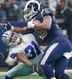 Dallas Cowboys free safety Byron Jones (31) takes a forearm from Los Angeles Rams running back Todd Gurley (30) on a time-consuming drive in the fourth quarter during the Los Angeles Rams vs. the Dallas Cowboys NFL football game at AT&T Stadium in Arlington, Texas on Sunday, October 1, 2017. (Louis DeLuca/The Dallas Morning News)