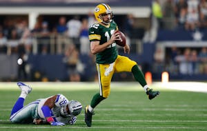 Green Bay Packers quarterback Aaron Rodgers (12) shakes Dallas Cowboys defensive tackle David Irving (95) as he rushes for 18 yards for a first down on a third down play in the last minute of play in the fourth quarter at AT&T Stadium in Arlington on Sunday, October 8, 2017. Green Bay Packers defeated the Dallas Cowboys 35-31. (Vernon Bryant/The Dallas Morning News)