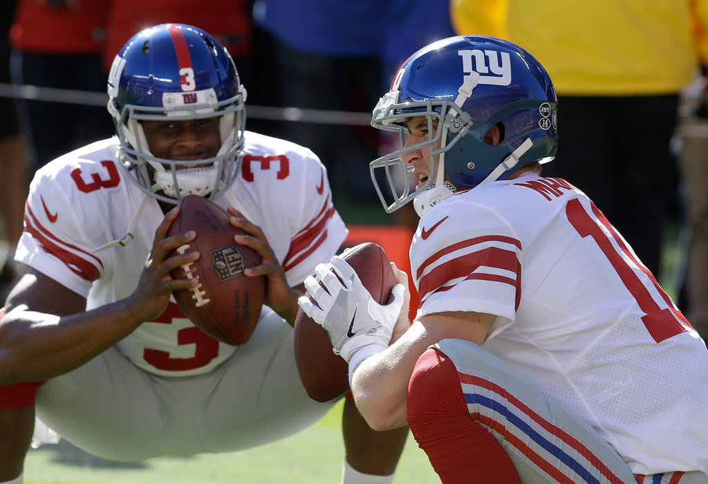 New York Giants quarterback Eli Manning gets face masked in the